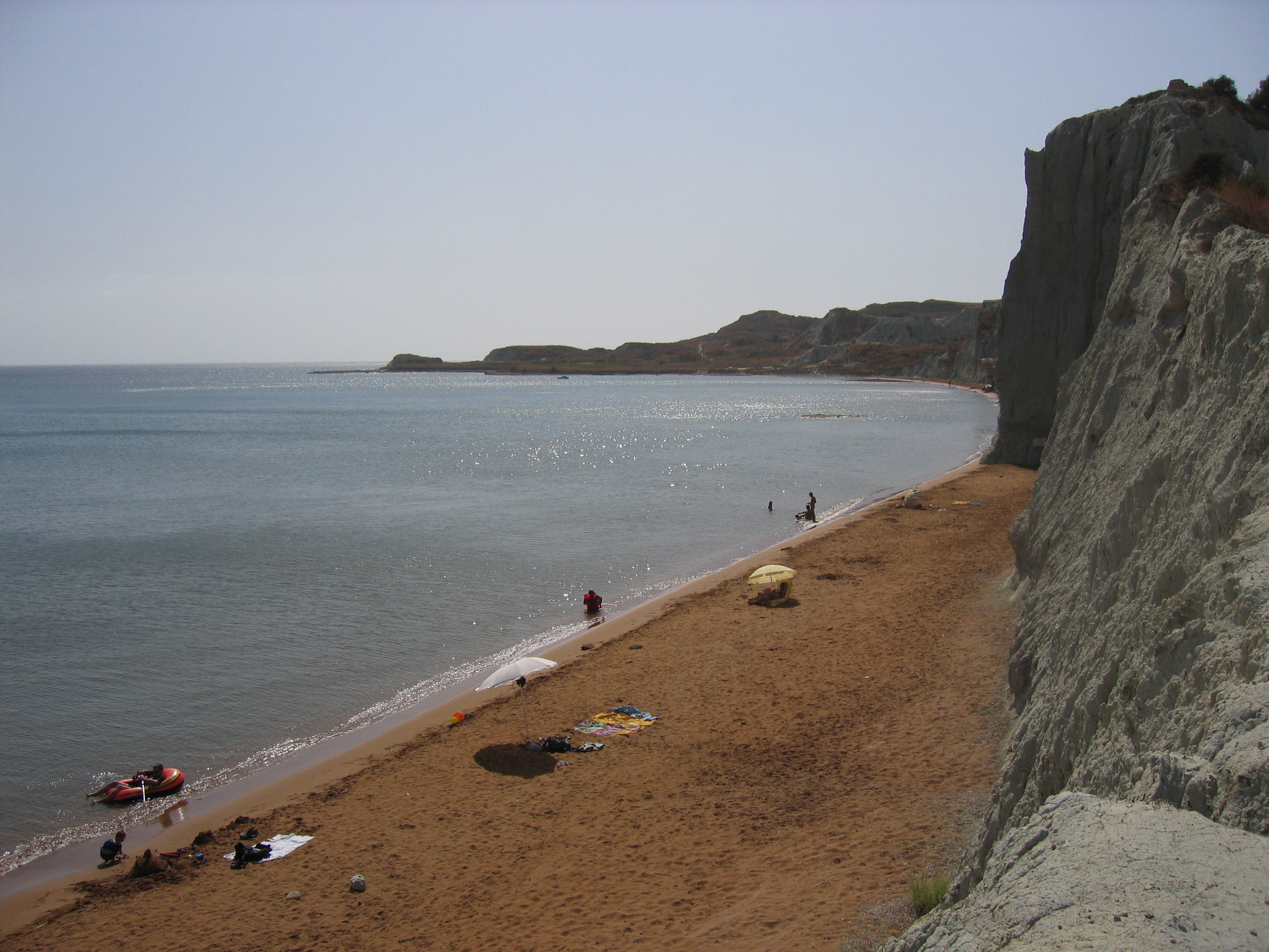 Xi Beach in Kefalonia, featuring a sandy shoreline with calm water conditions
