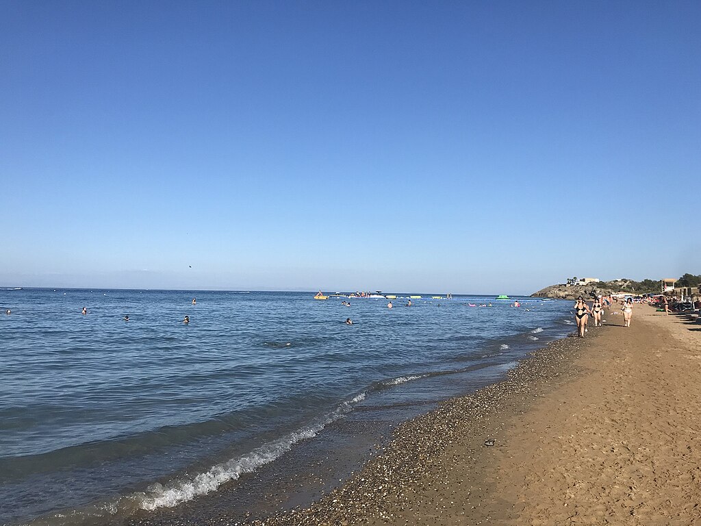 Banana Beach in Zakynthos, featuring a sandy shoreline with moderate water conditions, certified with Blue Flag status for environmental quality