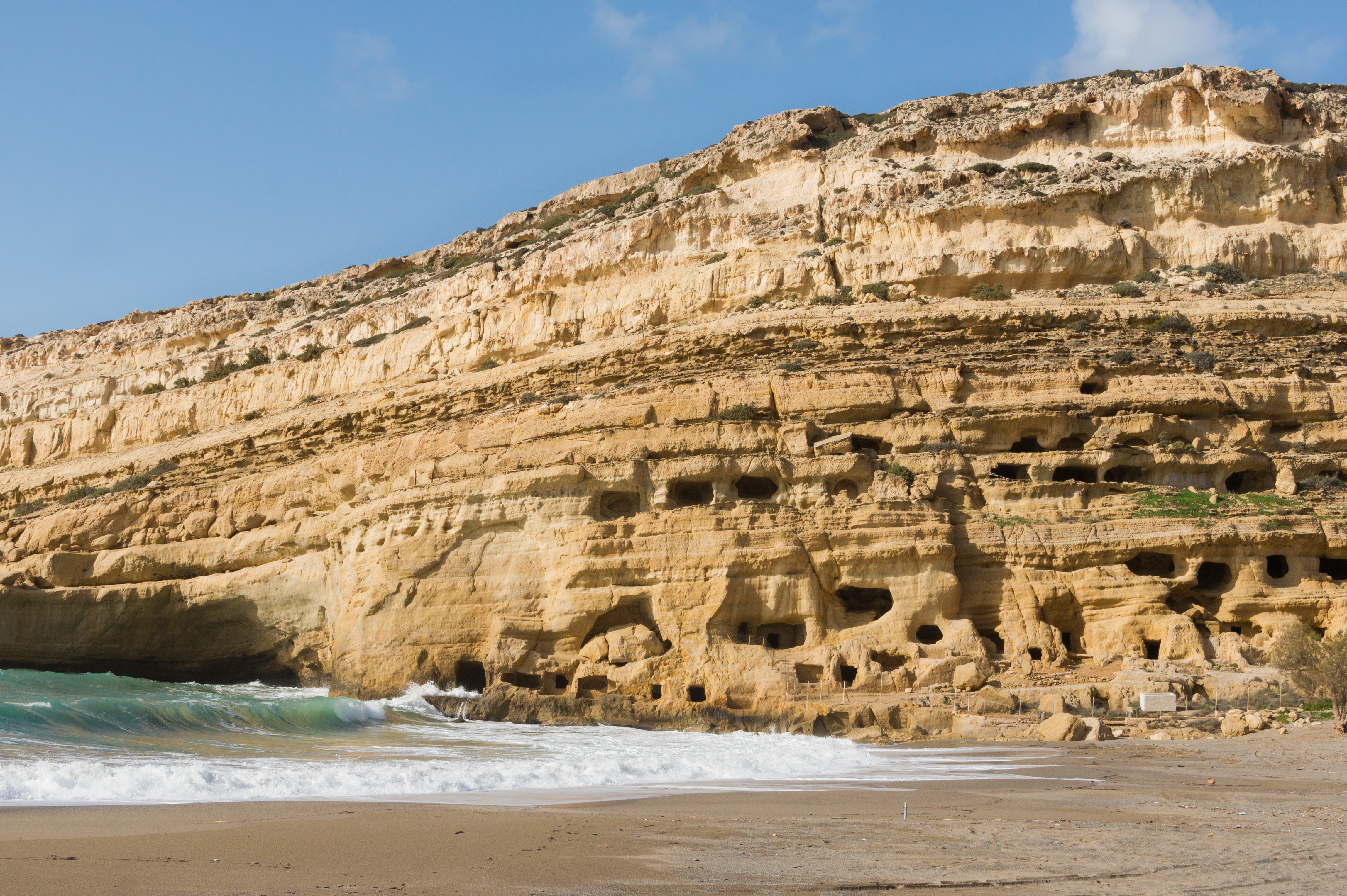 Matala Beach in Crete, featuring a sandy shoreline with calm water conditions