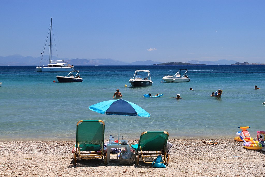 Dassia Beach in Corfu, featuring a mixed shoreline with calm water conditions, certified with Blue Flag status for environmental quality