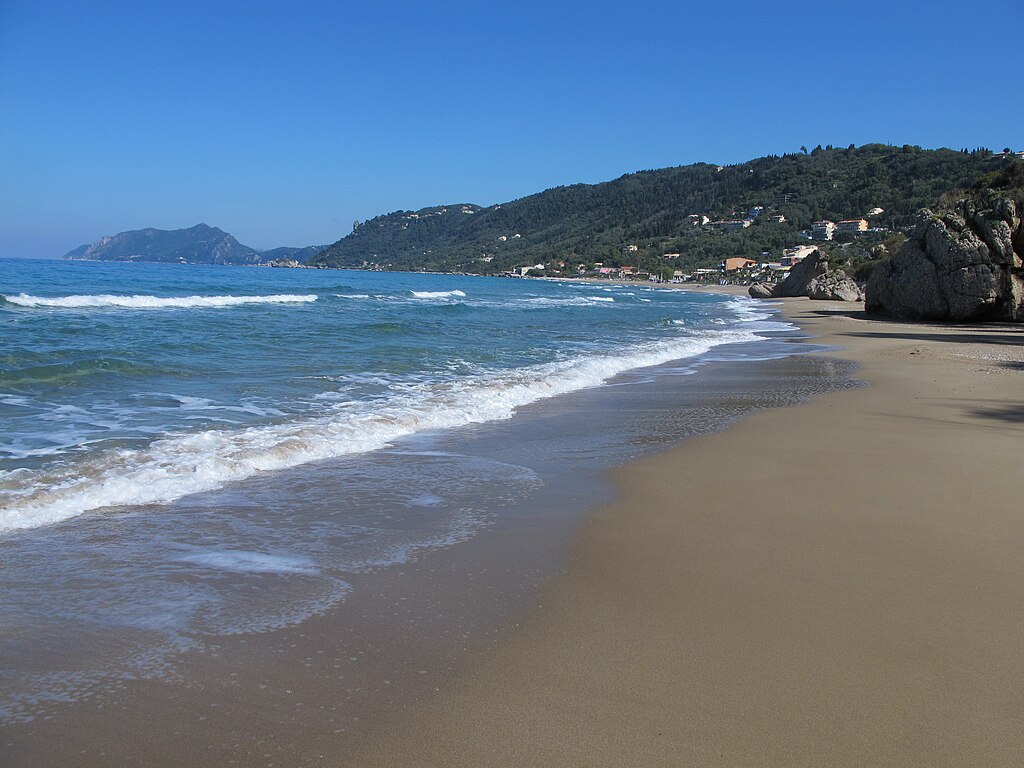 Agios Gordios Beach in Corfu, featuring a mixed shoreline with calm water conditions
