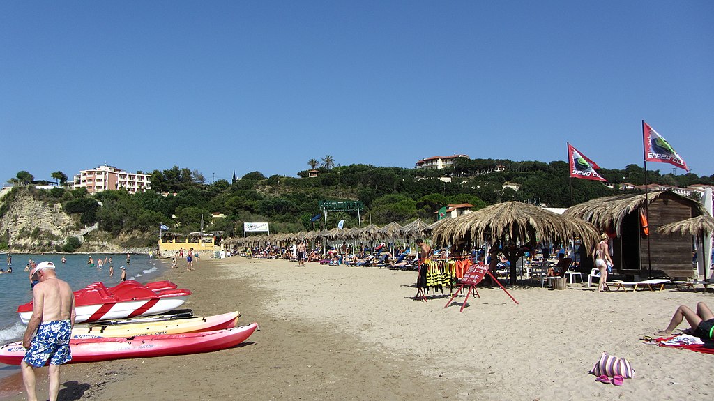 Tsilivi Beach in Zakynthos, featuring a sandy shoreline with calm water conditions, certified with Blue Flag status for environmental quality