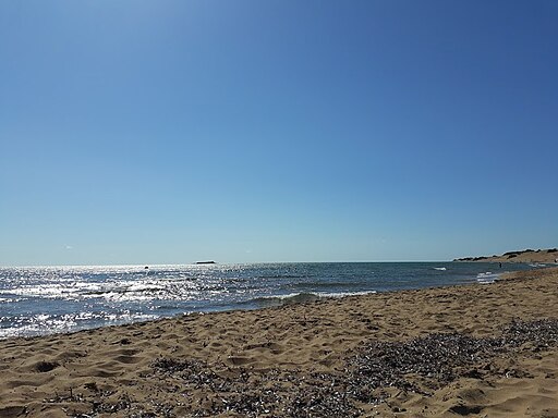 Issos Beach in Corfu, featuring a sandy shoreline with calm water conditions, certified with Blue Flag status for environmental quality