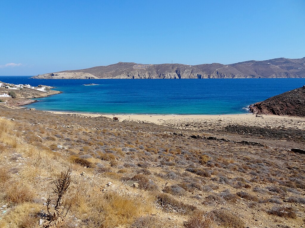 Agios Sostis Beach in Mykonos, featuring a sandy shoreline with calm water conditions