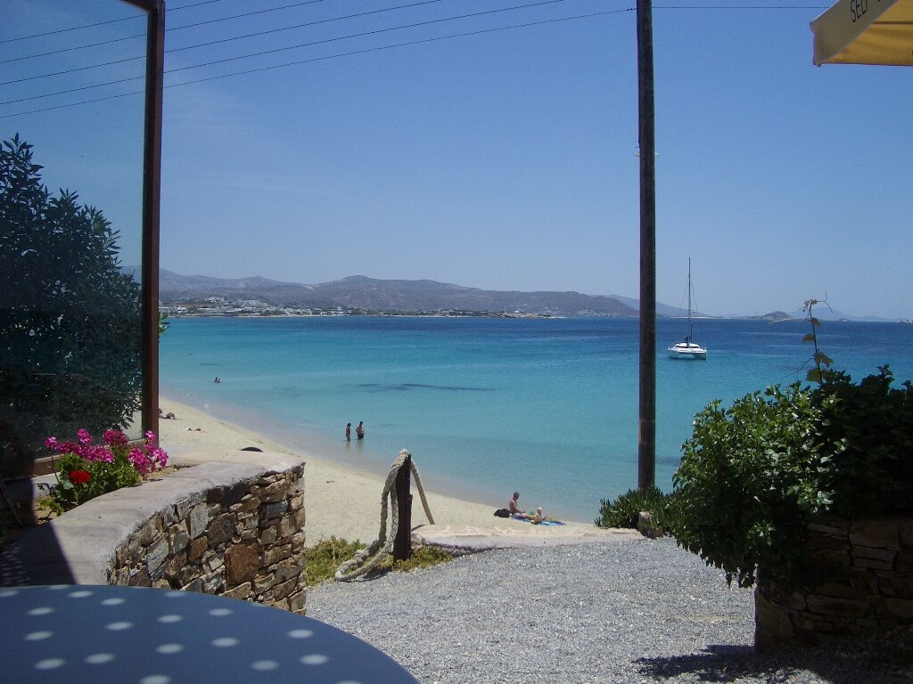 Agios Georgios Beach in Naxos, featuring a sandy shoreline with calm water conditions