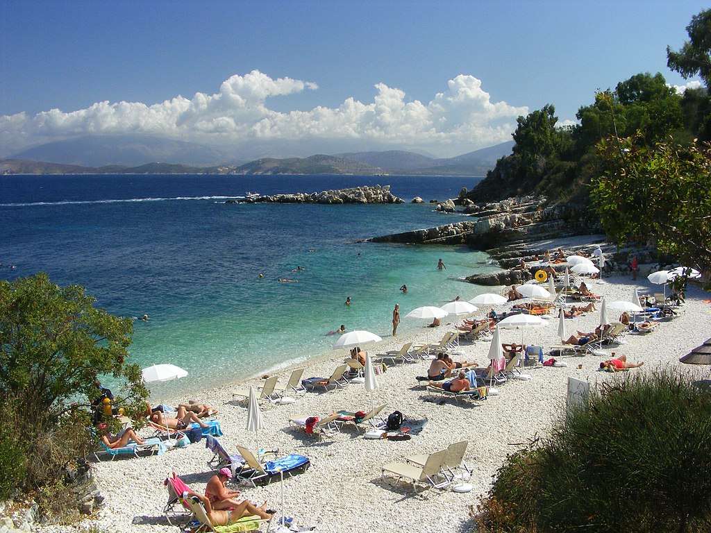Bataria Kassiopi Beach in Corfu, featuring a pebbly shoreline with calm water conditions