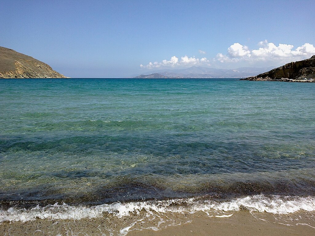 Molos Beach in Paros, featuring a sandy shoreline with calm water conditions