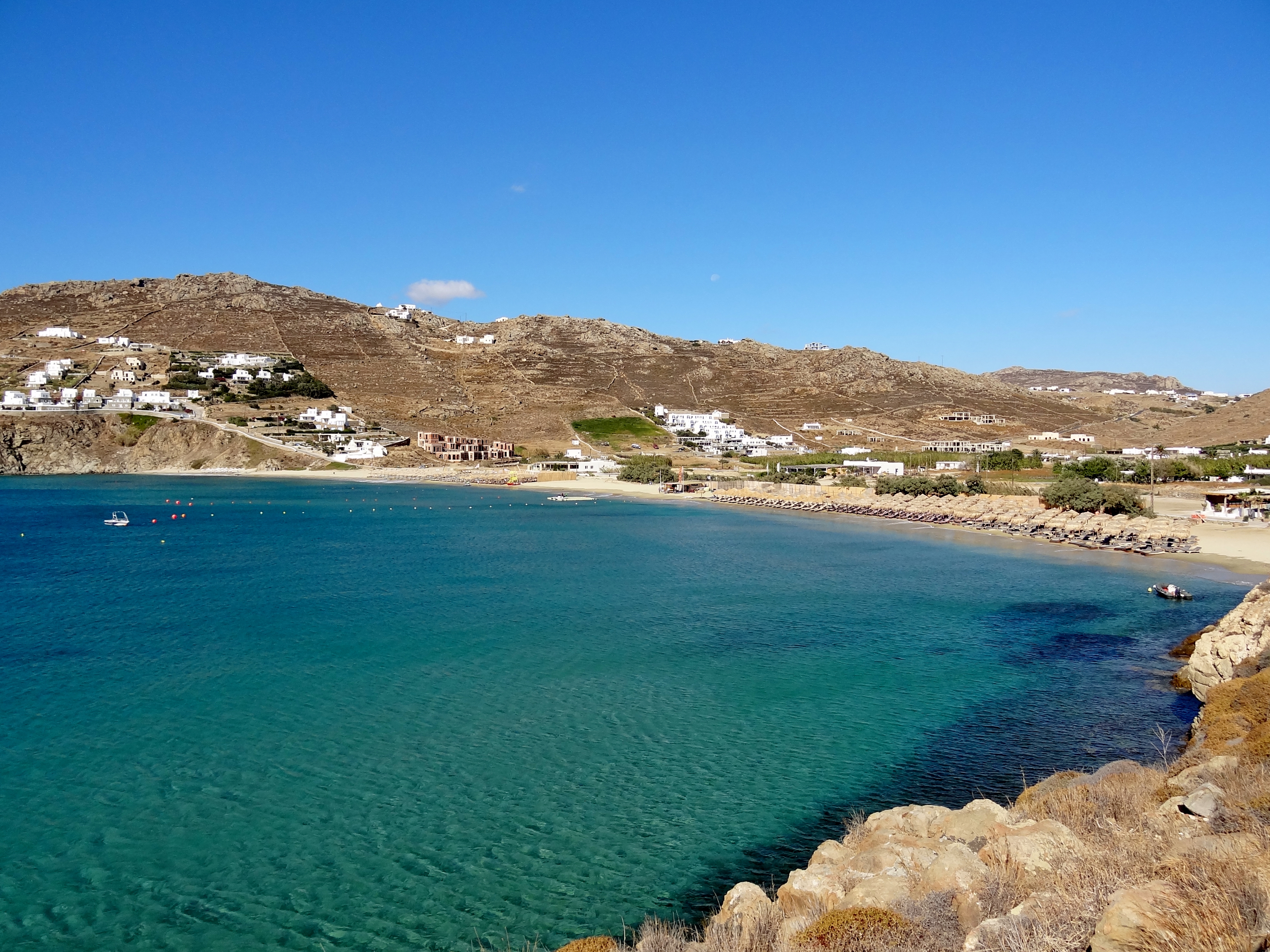 Kalo Livadi beach in Mykonos, featuring a sandy shoreline with calm water conditions