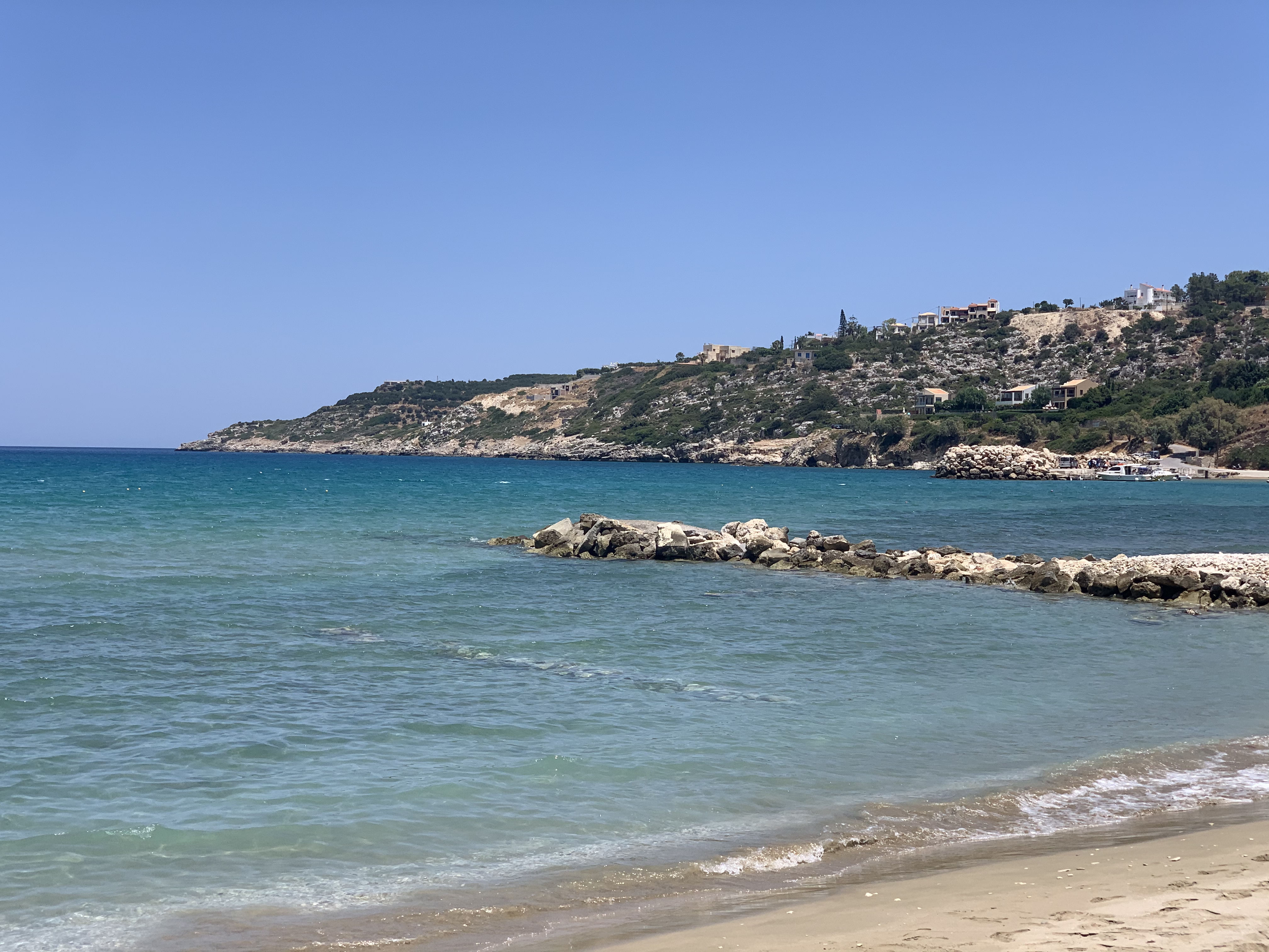Almyrida Beach in Crete, featuring a sandy shoreline with calm water conditions, certified with Blue Flag status for environmental quality