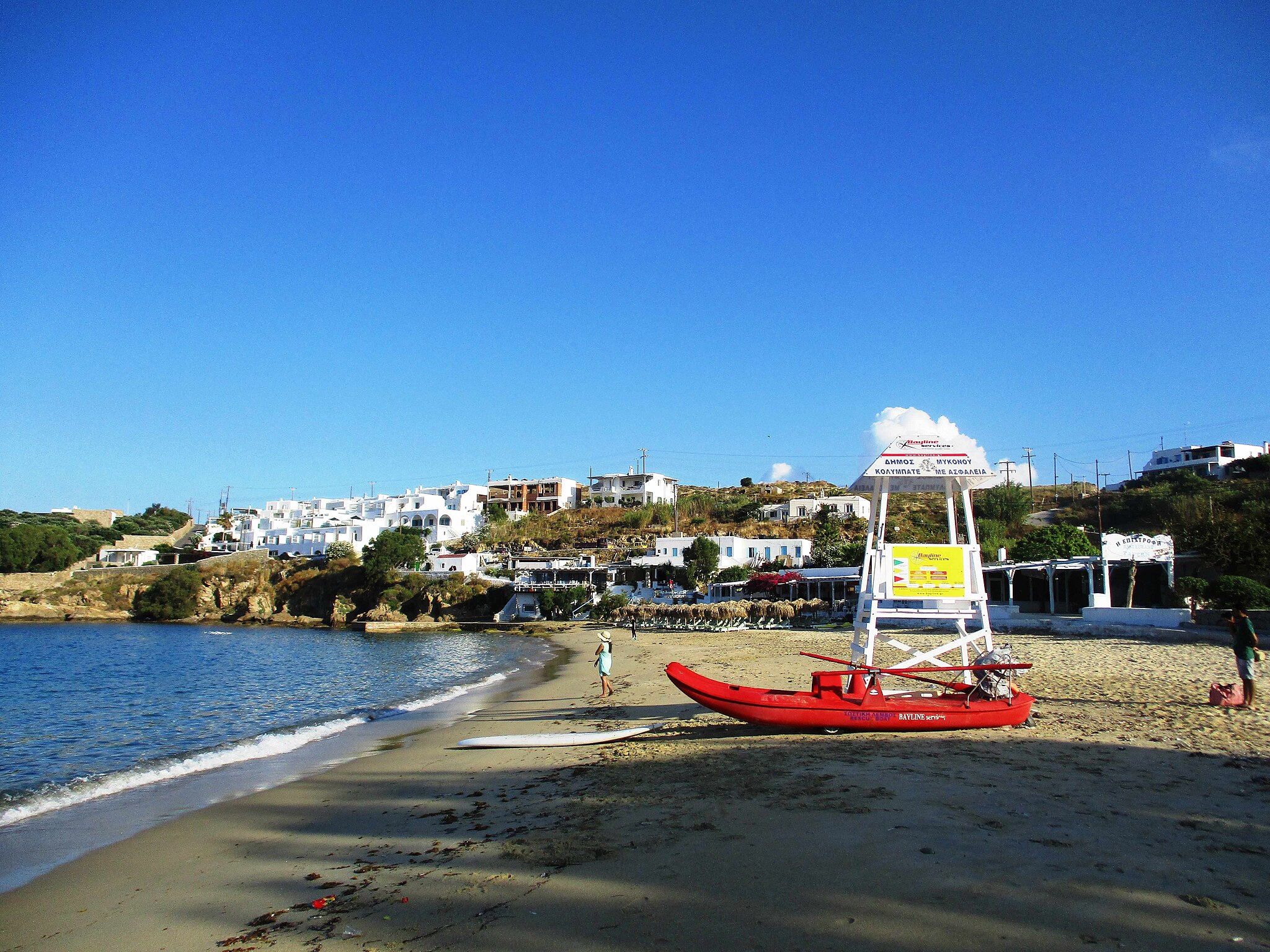 Agios Stefanos beach in Mykonos, featuring a sandy shoreline with calm water conditions