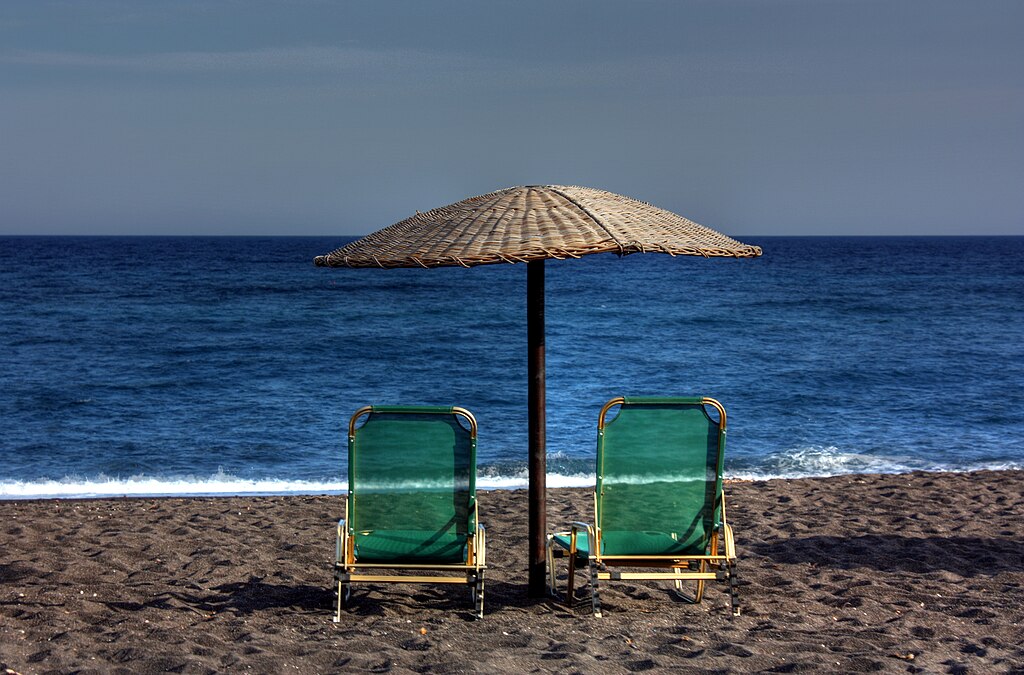 Perivolos Beach in Santorini, featuring a mixed shoreline with calm water conditions, certified with Blue Flag status for environmental quality